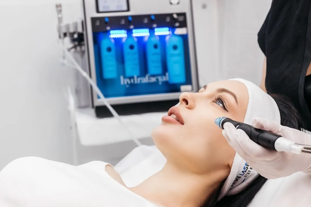 A person receiving a professional HydraFacial treatment at a clinic in Laguna Hills